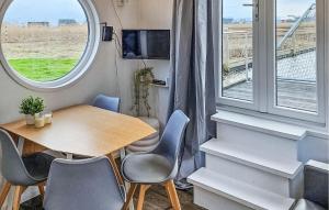 comedor con mesa, sillas y ventana en Aquacabin, en Leimuiden