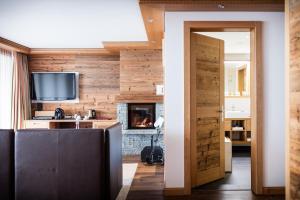 Elle comprend un salon doté de murs en bois et d'une cheminée. dans l'établissement Petit Chalet by Schönegg, à Zermatt