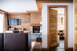 sala de estar con paredes de madera y chimenea en Petit Chalet by Schönegg, en Zermatt