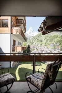 ツェルマットにあるPetit Chalet by Schöneggの椅子付きの窓から山の景色を望めます。