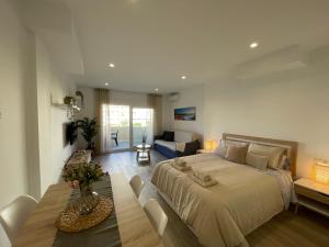 a bedroom with a large bed and a dining room at Benal Beach Estudio Playa in Benalmádena
