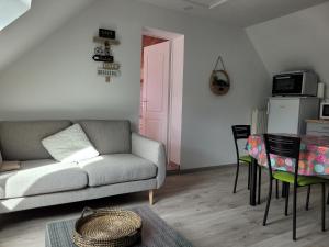 a living room with a couch and a table at Gîte Évasion idyllique à l'étage près zoo-chateaux in Faverolles-sur-Cher