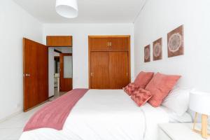 een slaapkamer met een groot wit bed met oranje kussens bij MV Brand New Apartment downtown Sevilla MartinVilla in Sevilla