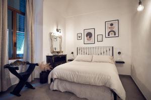 a white bedroom with a bed and a mirror at A ca' de Lisetta in Albenga