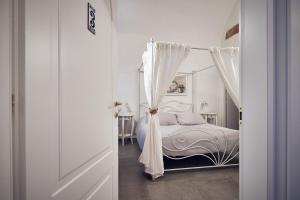 a bedroom with a white bed with a canopy at A ca' de Lisetta in Albenga