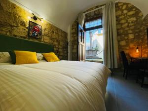 ein Schlafzimmer mit einem Bett mit gelben Kissen und einem Fenster in der Unterkunft Casa Soderini in Tarquinia