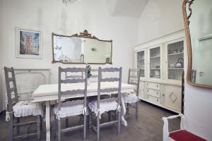 a dining room with a table with chairs and a mirror at A ca' de Lisetta in Albenga