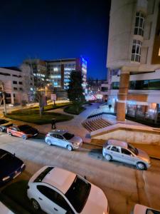 un grupo de autos estacionados en un estacionamiento por la noche en 24 Shades of Grey, apartament central, ceai, cafea, filtru apa rece-fierbinte, pat 160 cm cu saltea memory foam en Craiova