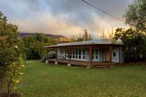 a small house in a field of green grass at River Studio in Barrydale