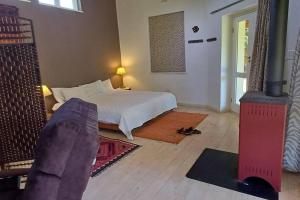a bedroom with a bed and a room with a fireplace at River Studio in Barrydale
