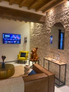 un salon avec un ours en peluche assis sur une chaise dans l'établissement Maison Authentique « Bleue Nuits », à Nuits-Saint-Georges