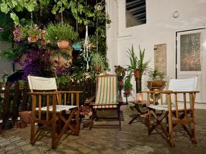 three chairs and a table in a yard with plants at BBmontejunto in Cadaval