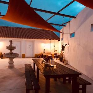 a patio with a wooden table and a fountain at BBmontejunto in Cadaval