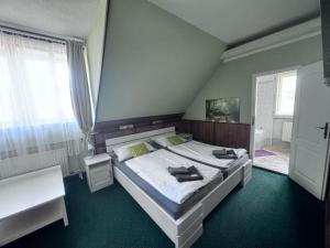 A bed or beds in a room at Penzion Landštejnský dvůr
