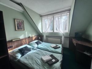 Penzion Landštejnský dvůr في سلافونيتسا: غرفة نوم عليها سرير ووسادتين