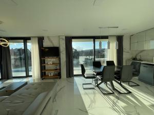 cocina y sala de estar con mesa y sillas en Luxury Apartments in Balatonalmádi, Almádi Lux Apartman II - Crystal White, en Balatonalmádi