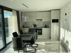 een keuken met een eettafel en stoelen bij Luxury Apartments in Balatonalmádi, Almádi Lux Apartman II - Crystal White in Balatonalmádi