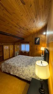 um quarto com uma cama num quarto de madeira em Location appartement dans Maison Basque em Urcuit