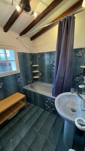 uma casa de banho com uma banheira, um lavatório e um WC. em Location appartement dans Maison Basque em Urcuit