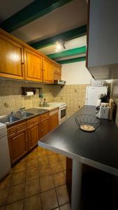 uma cozinha com armários de madeira e uma bancada em Location appartement dans Maison Basque em Urcuit
