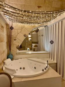 a bath tub sitting in a room with lights at Vittorio Emanuele Charming Suites in Monopoli