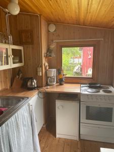uma pequena cozinha com um fogão e uma janela em Gotland,Bungeviken em Fårösund