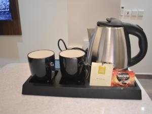 a coffee pot and two mugs on a counter at كيان للأجنحة الفندقية- احد رفيده in Rabba