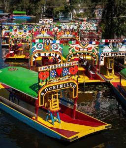 a group of colorful boats parked in the water at Urban Style Retreat, Rooftop Views, CDMX 4 in Mexico City +42 photos