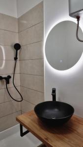 La salle de bains est pourvue d'un lavabo noir sur une table en bois. dans l'établissement Rogdogg apartments center Zadar, à Zadar