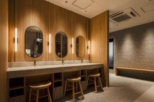 a bathroom with three sinks and three mirrors at Hotel Keihan Sapporo in Sapporo