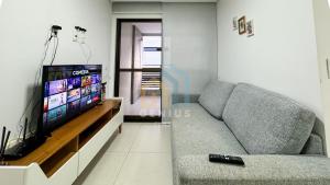 uma sala de estar com um sofá e uma televisão de ecrã plano em Eco Summer Tambaú - Apartamentos de 2 Quartos por Genius Flats em João Pessoa