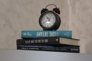 a clock sitting on top of a stack of books at Ellebi in Vibo Valentia