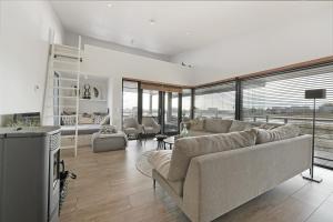 a living room with a couch and a tv at Seaside Panorama Villa 6p - Direct aan de Baai - Villa 37 in Ouddorp