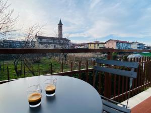 a table with two glasses sitting on a balcony at Elegante Appartamento Tre Amis - Doppio Garage & Free WiFi in Centallo