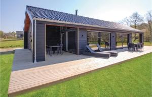 ein Haus mit einer Holzterrasse im Gras in der Unterkunft Awesome Home In Haderslev With Kitchen in Kelstrup