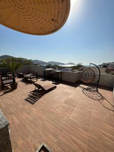 un patio con mesas de picnic y bancos en el techo en Arraial Hospedagem, en Arraial do Cabo