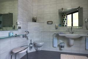 a bathroom with a sink and a toilet and a mirror at Hotel Deutsches Haus in Lampertheim