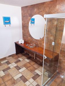 a bathroom with a sink and a mirror at Suítes Praia Barequeçaba in São Sebastião