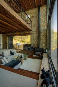 a living room with a couch and a tv at Heartbeat Mountain Escapes in Kato Trikala Korinthias