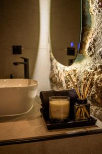 a bathroom with a sink and a mirror and a candle at Heartbeat Mountain Escapes in Kato Trikala Korinthias