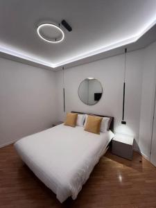 a bedroom with a large white bed and a mirror at Apartment Aurora Rho Fiera in Milan