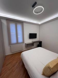a bedroom with a white bed and a television at Apartment Aurora Rho Fiera in Milan