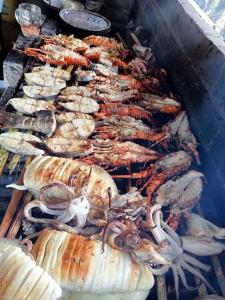 ein paar verschiedene Arten von Meeresfrüchten auf einem Grill in der Unterkunft Apartment on the Sand in Watamu