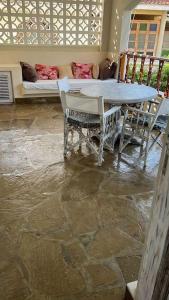 a patio with a table and chairs and a couch at Apartment on the Sand in Watamu