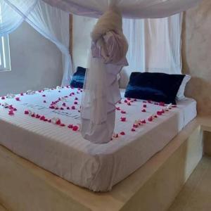 ein Bett mit einem Hochzeitskleid und Rosen darauf in der Unterkunft Apartment on the Sand in Watamu