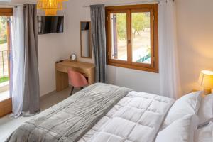a bedroom with a bed and a desk and a window at Kostis Orange Resort in Volos