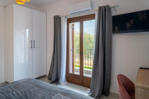a bedroom with a sliding glass door to a balcony at Kostis Orange Resort in Volos