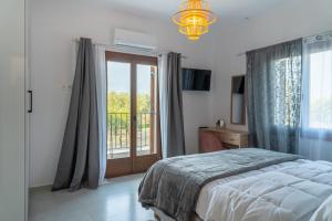 a bedroom with a bed and a sliding glass door at Kostis Orange Resort in Volos