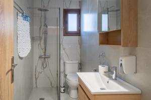a bathroom with a shower and a toilet and a sink at Kostis Orange Resort in Volos