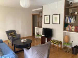 uma sala de estar com um sofá, uma mesa e uma televisão em Modern & cosy Apartment in Jaca Pyrenees Spain em Jaca